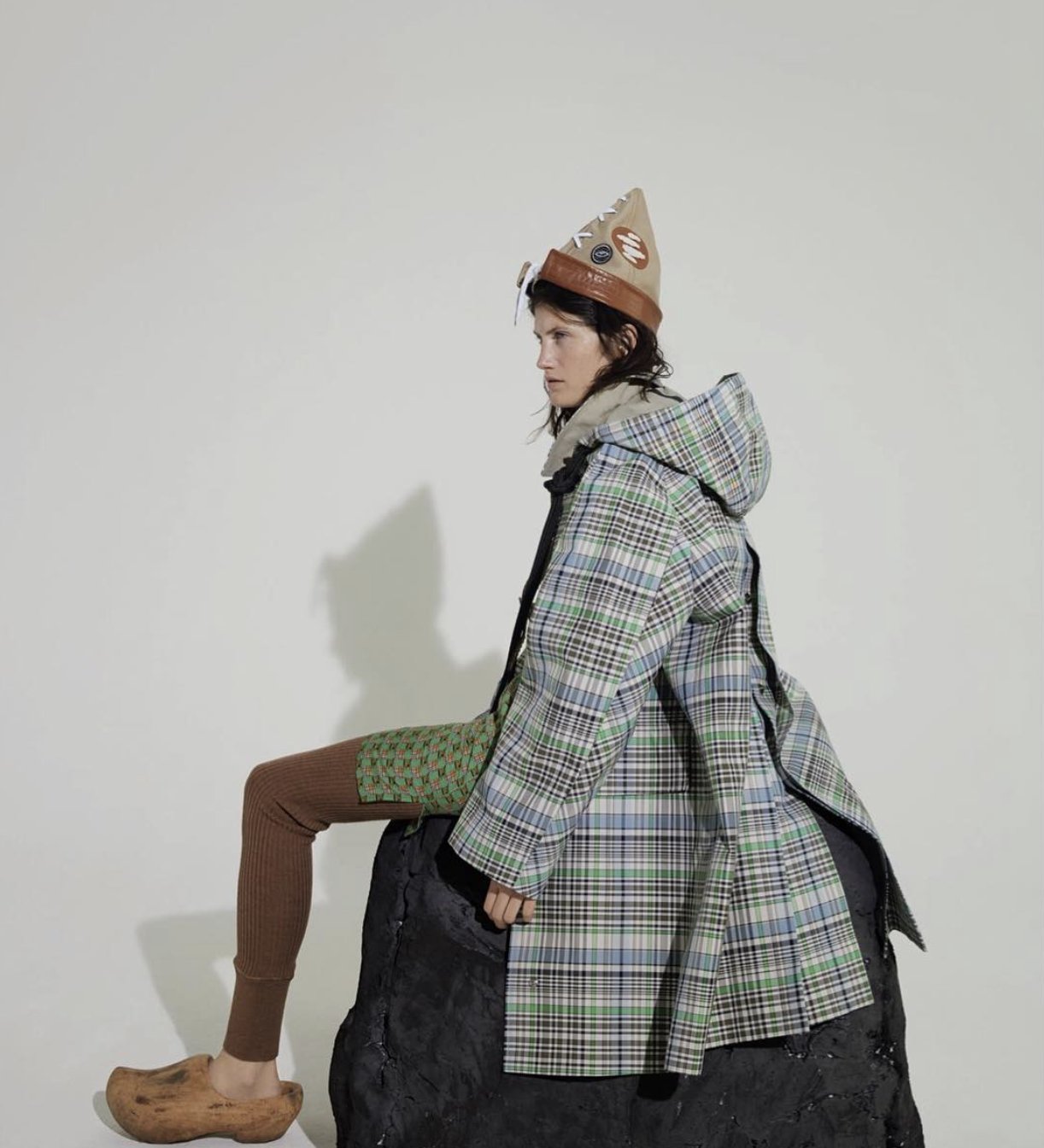 Studio fashion editorial, checked coat and sculptural set piece